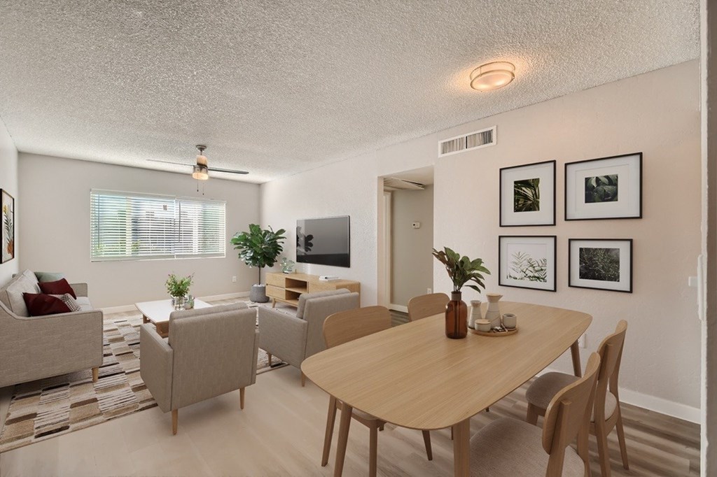 A living room with a couch, chairs, and a dining table.