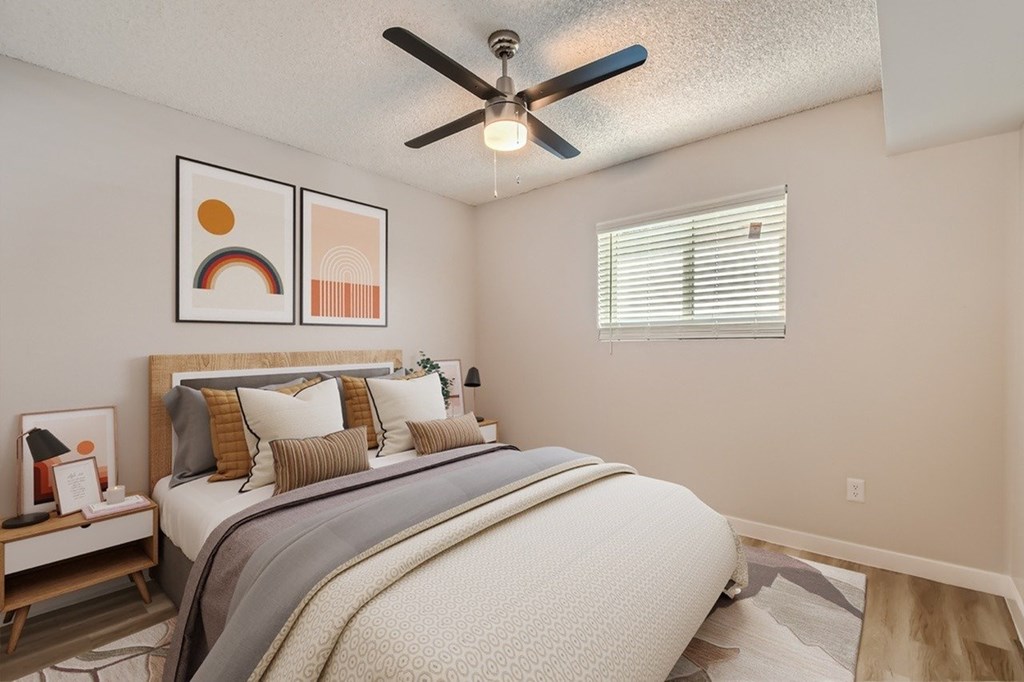 A bedroom with a large bed and a ceiling fan.