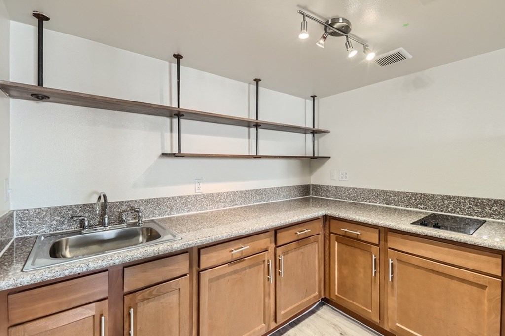 A kitchen with wooden cabinets and a granite countertop.