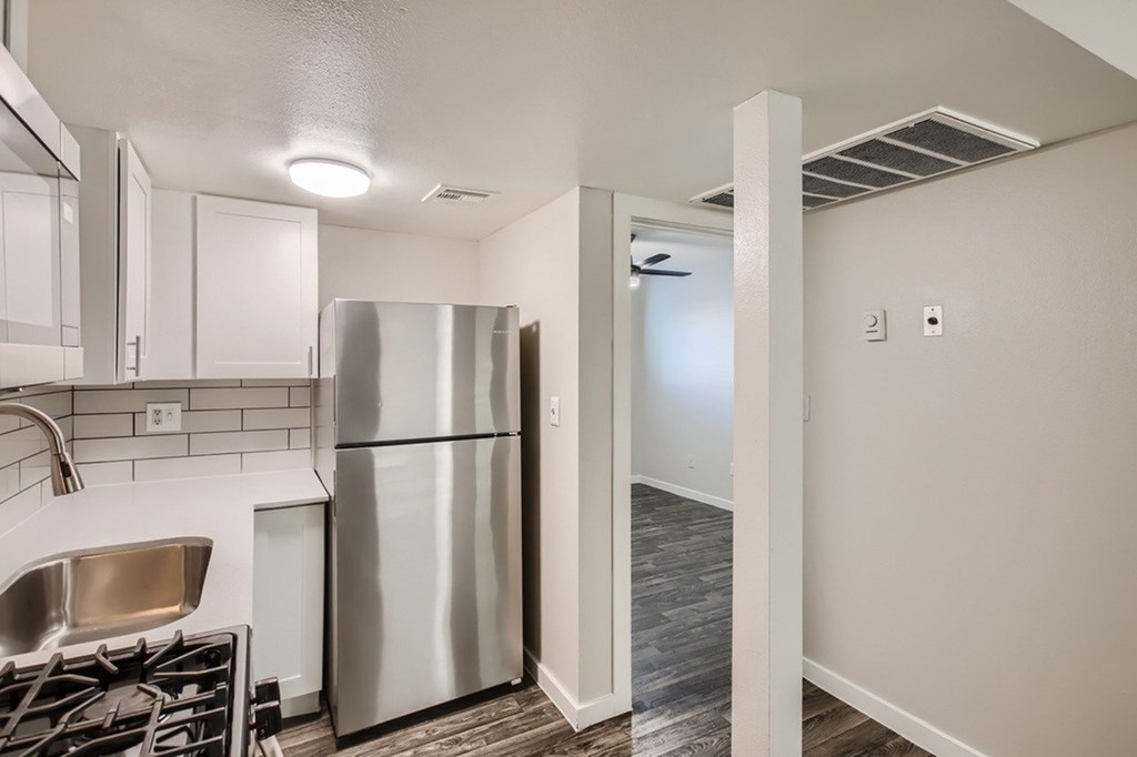 A kitchen with a stainless steel refrigerator and a sink.