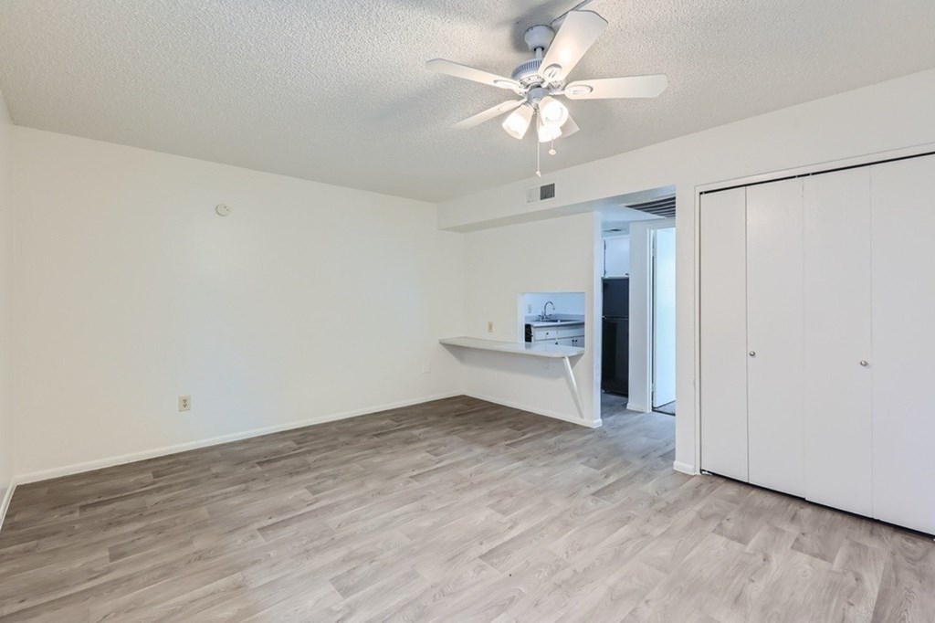 A room with a ceiling fan and a white cabinet.