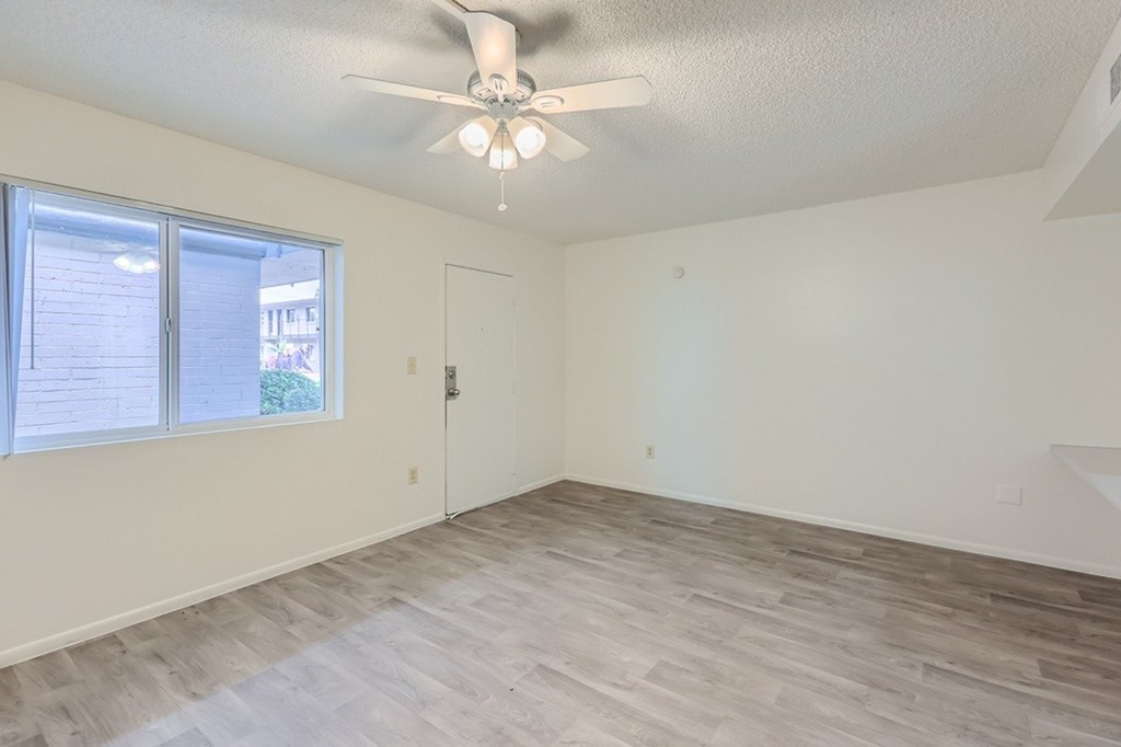 A room with a ceiling fan and a door.