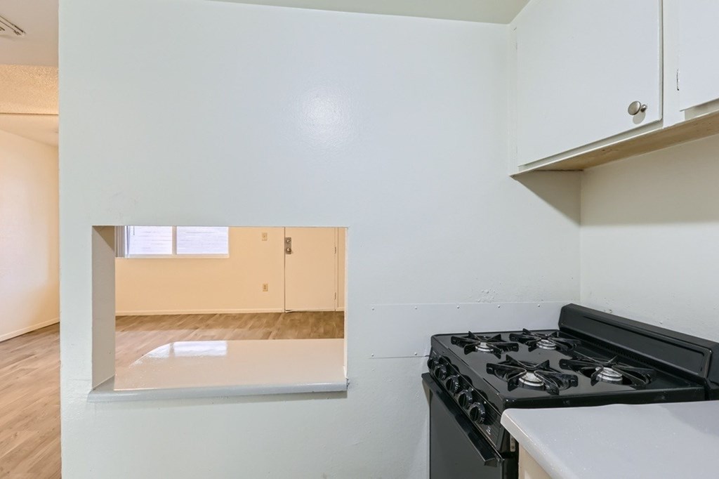 A kitchen with a black stove top oven and white cabinets.