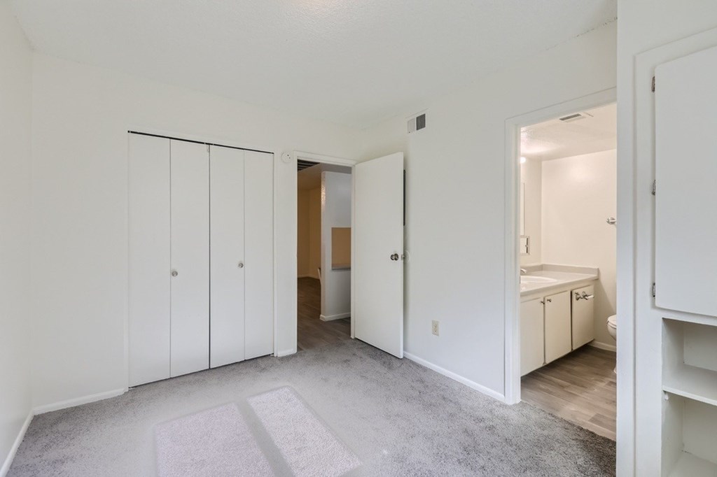 A white room with a grey carpet and a white door.