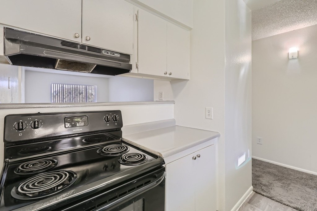 A black stove top oven in a white kitchen.