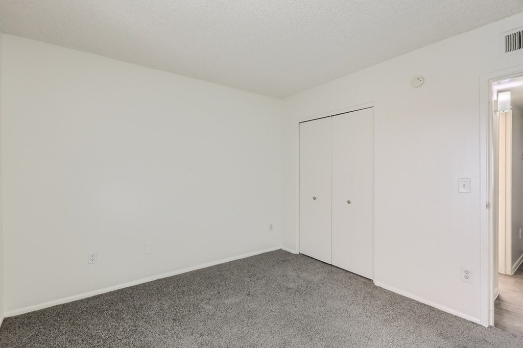 A room with a carpeted floor and a white door.