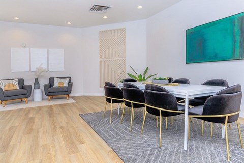 A dining room with a white table and black chairs.