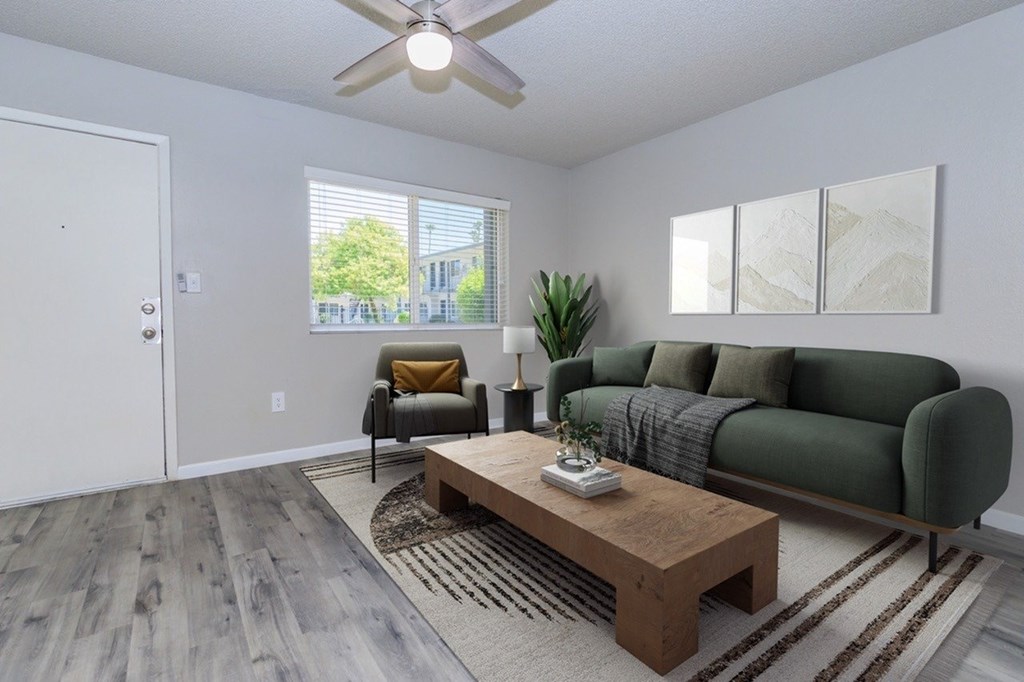 A living room with a green couch, a brown coffee table, and a ceiling fan.