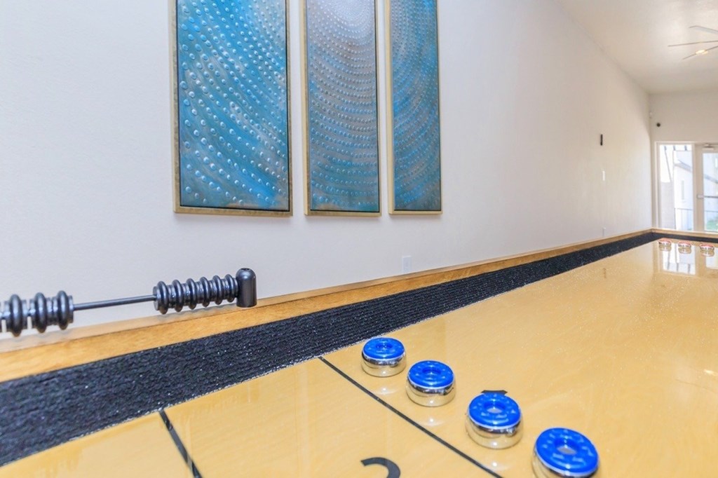 A room with a long table and two paintings on the wall.