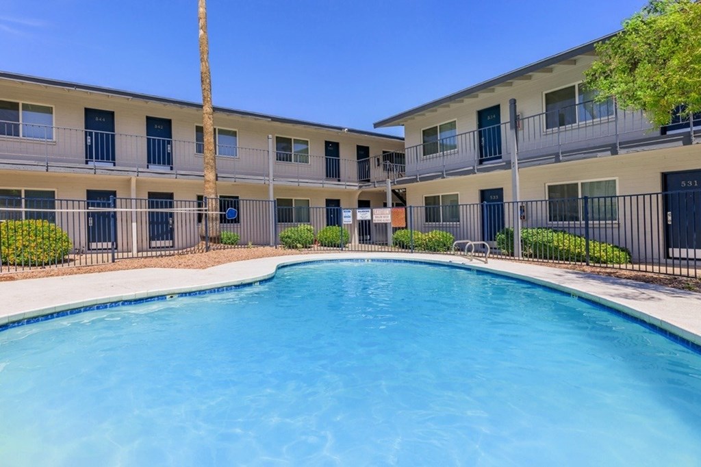A swimming pool in front of apartment buildings.