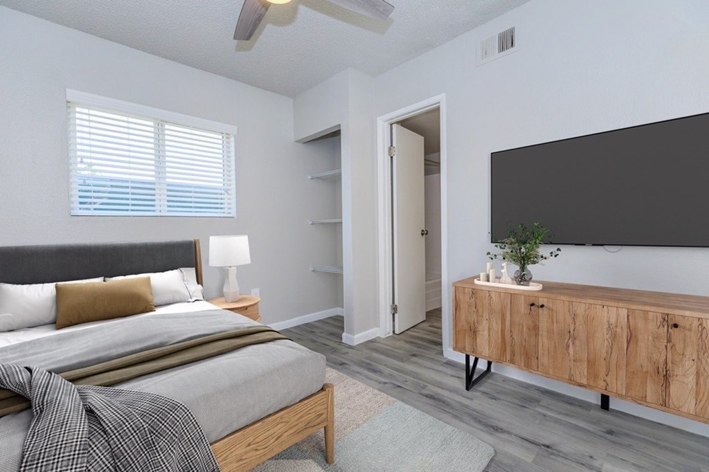A bedroom with a bed, a wooden cabinet, and a ceiling fan.