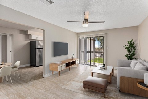 A modern living room with a flat screen TV, a white sofa, and a dining table with chairs.