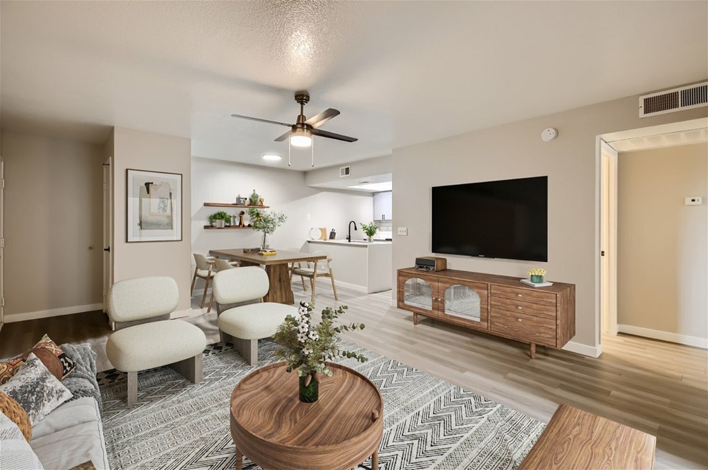 A living room with a wooden coffee table and a flat screen TV.
