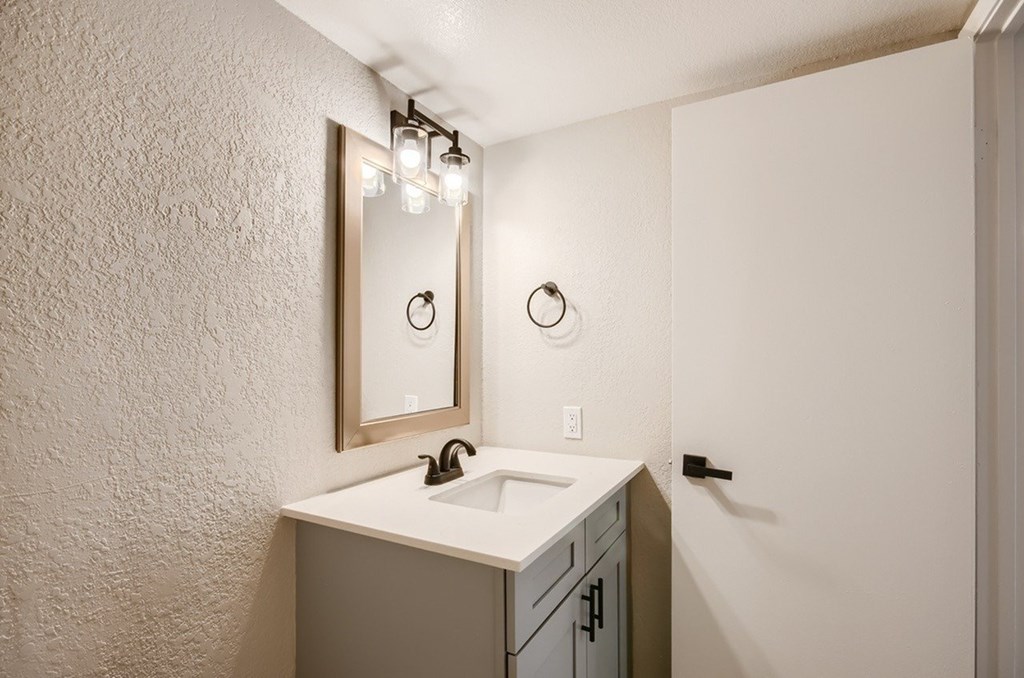 A bathroom with a sink and a mirror.