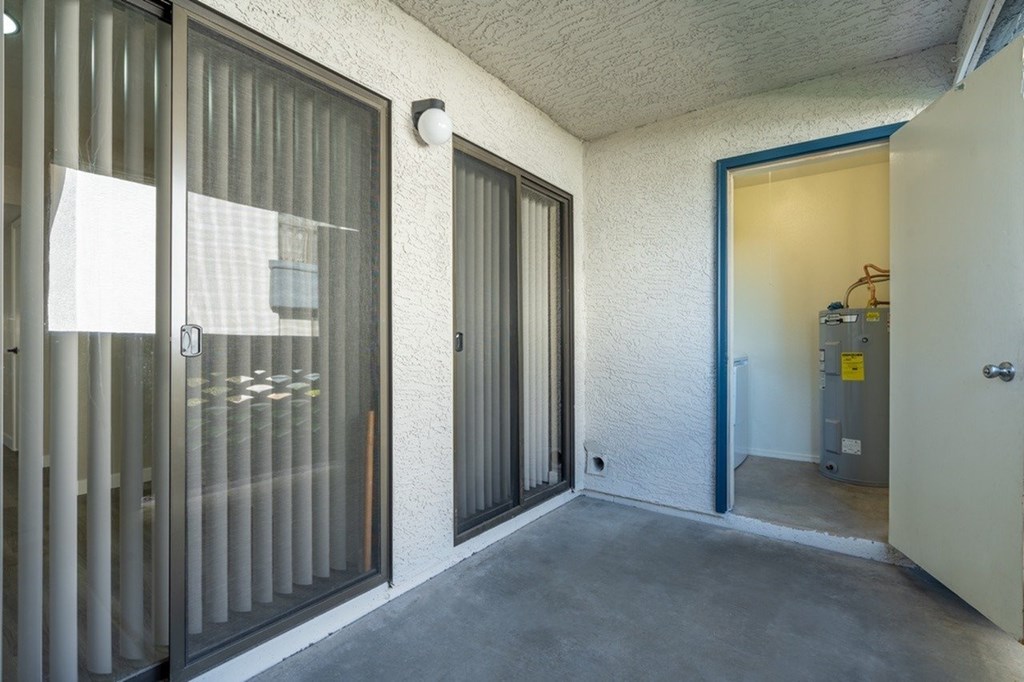 A room with a door and a window with blinds.