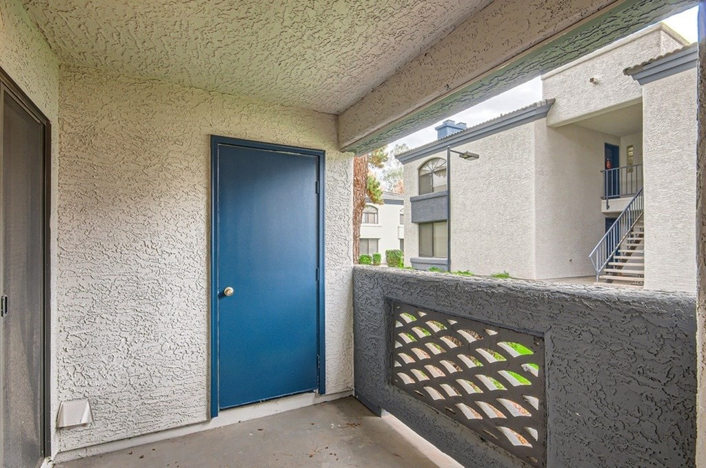 A blue door is on the left side of a concrete wall.