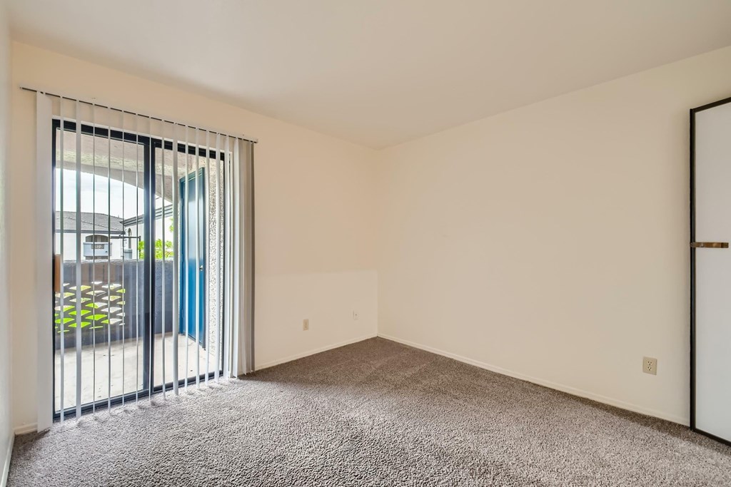 A room with a grey carpet and a white door.