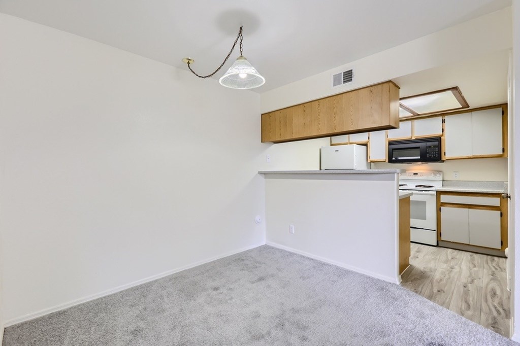 A kitchen with white walls and a wooden counter.