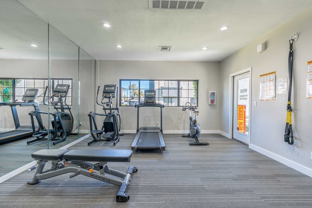 A gym with treadmills, exercise bikes, and weight machines.
