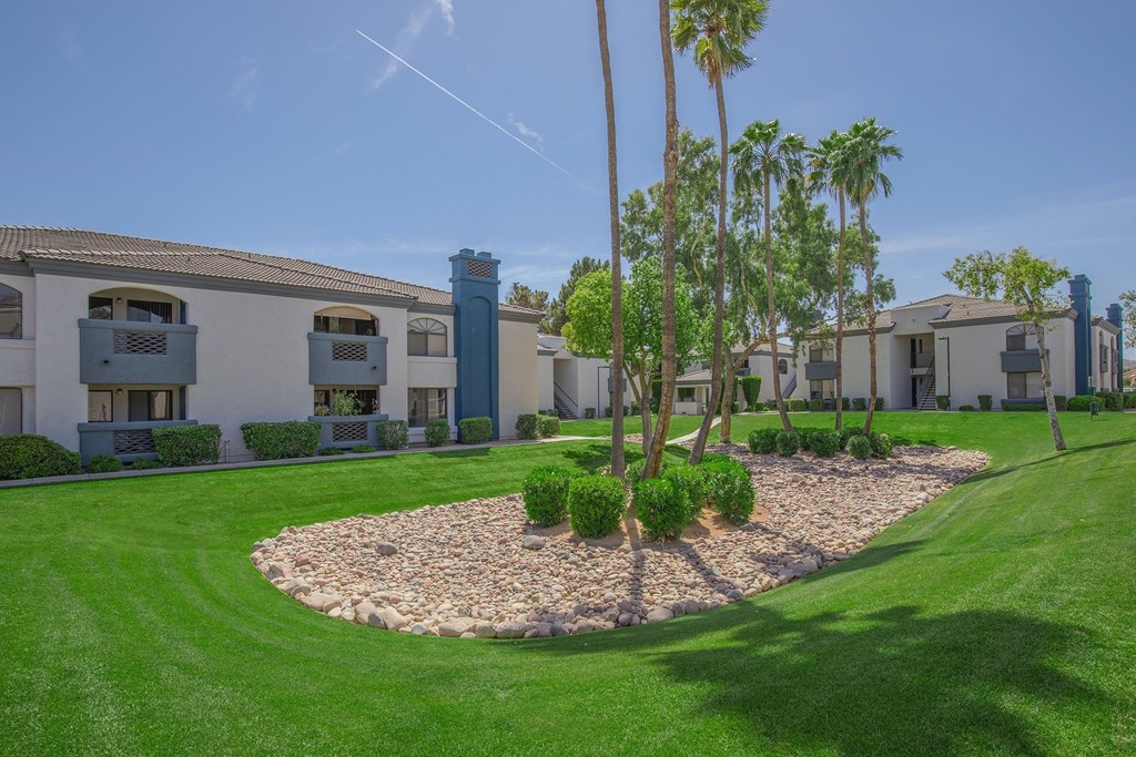 A sunny day at a well-maintained housing complex with a clear blue sky.
