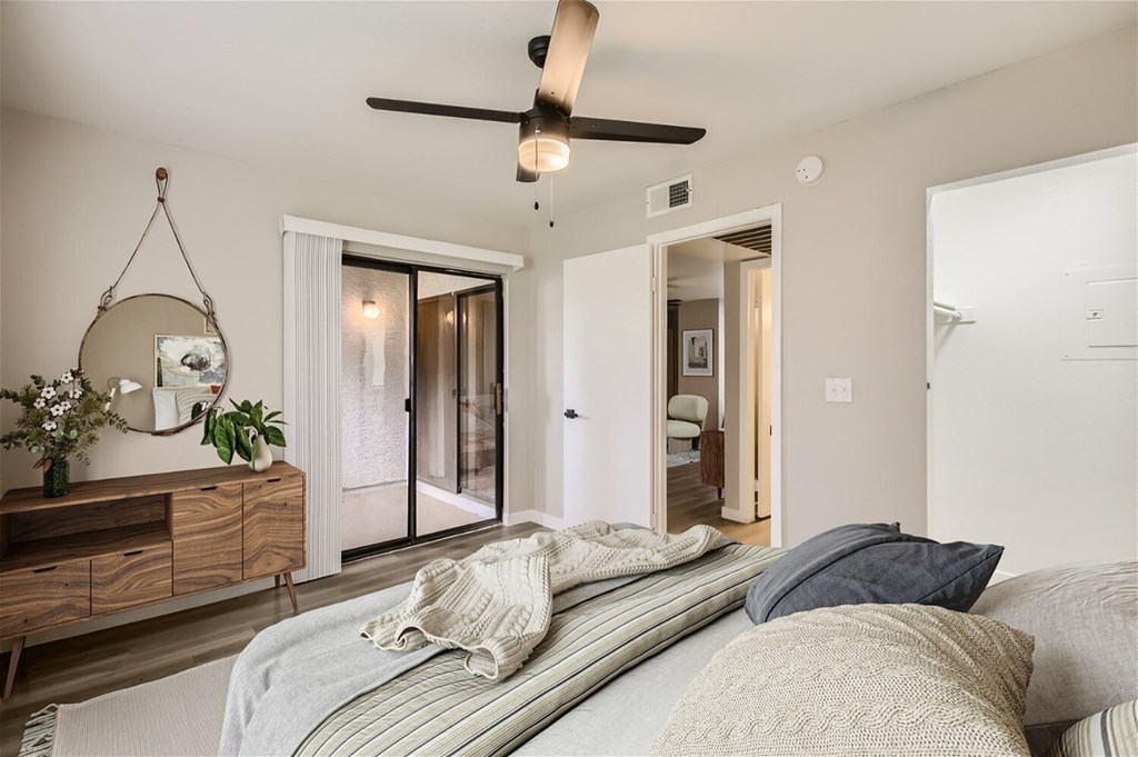 A bedroom with a bed, a dresser, and a mirror.