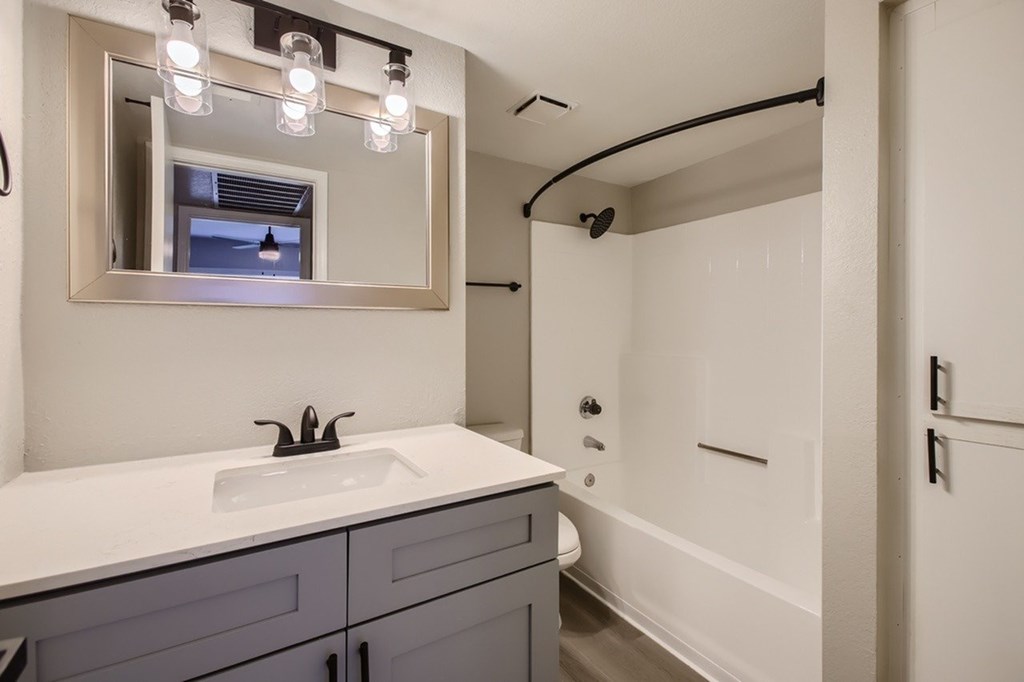 A bathroom with a white sink and a mirror above it.