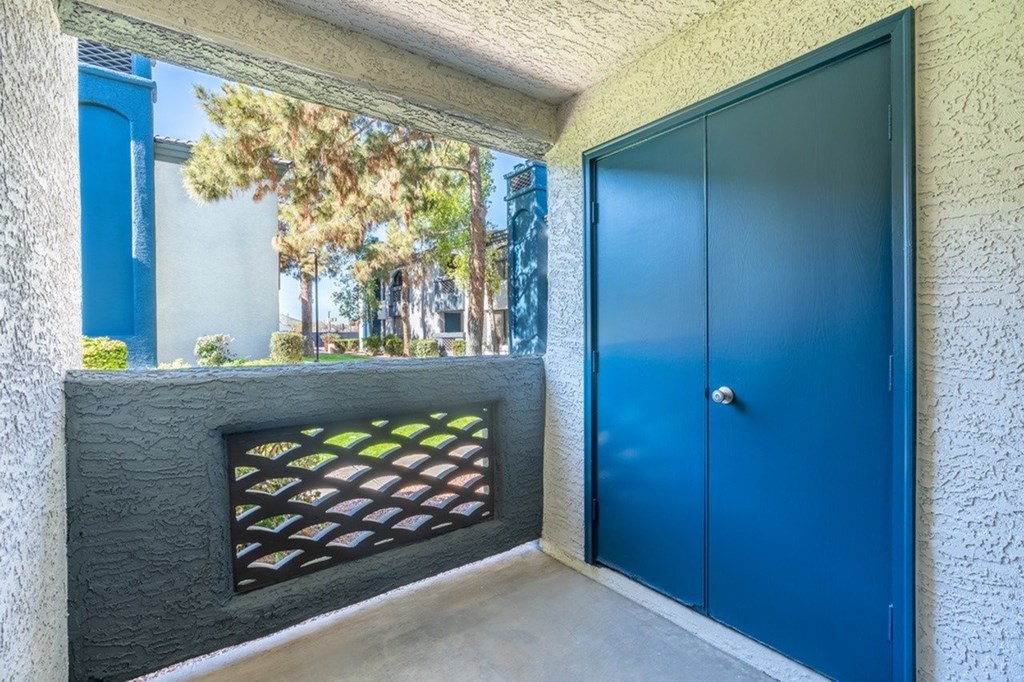 A blue door is on the right side of a concrete wall.