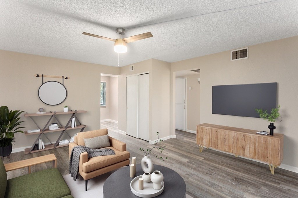 A living room with a couch, a chair, a table, and a television.