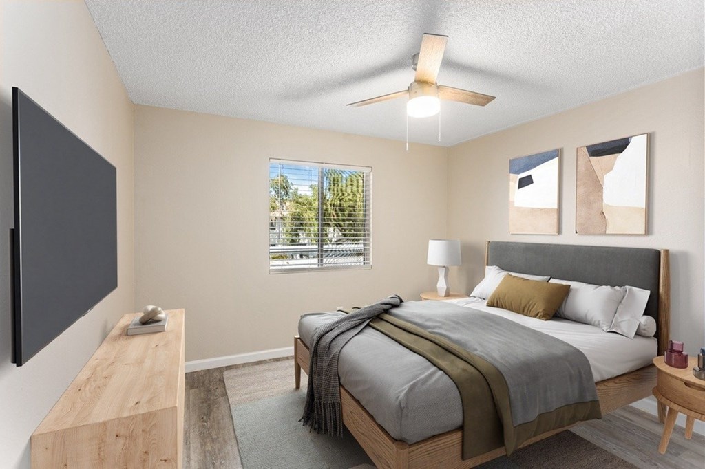 A bedroom with a large bed and a flat screen TV mounted on the wall.