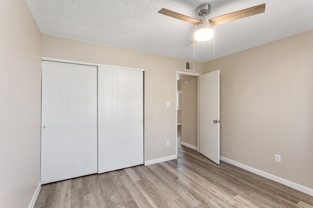 A room with a ceiling fan and two doors.