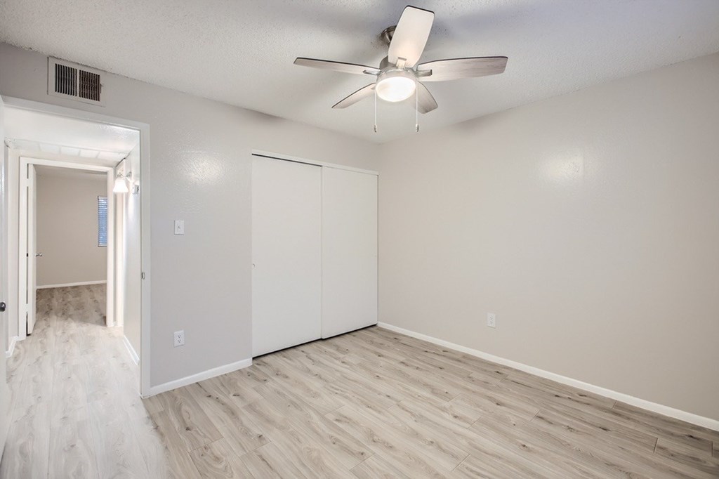 A room with a ceiling fan and two white doors.