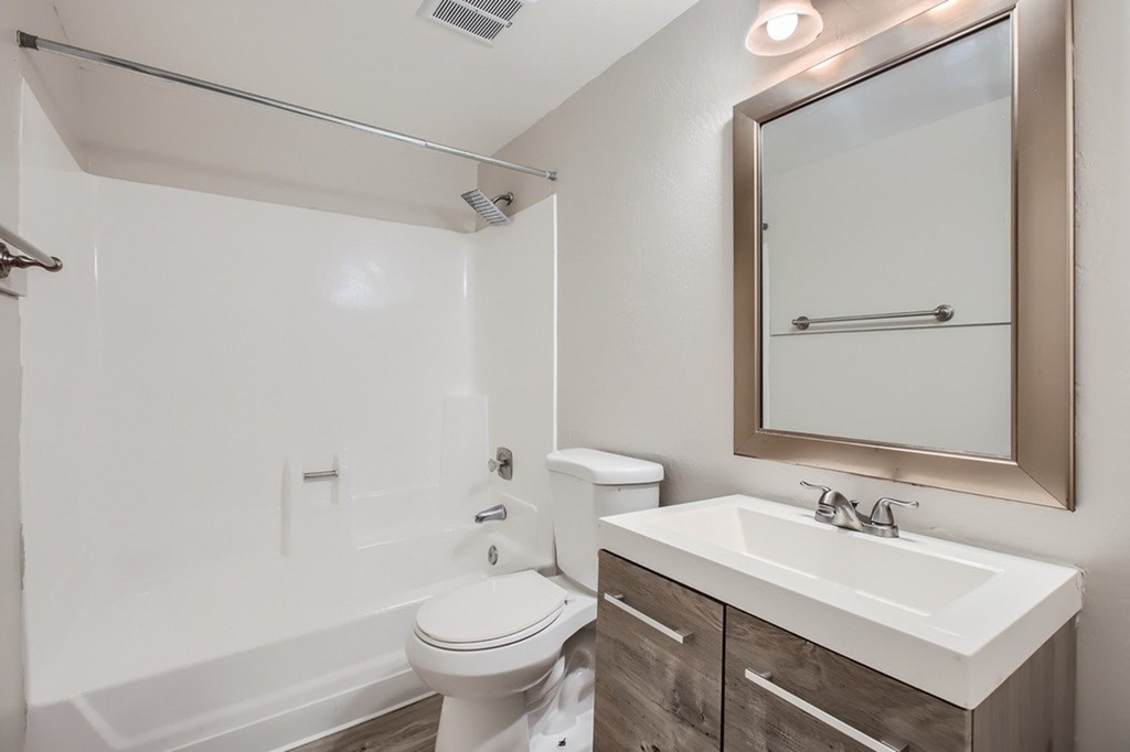 A white toilet sits next to a sink in a bathroom.