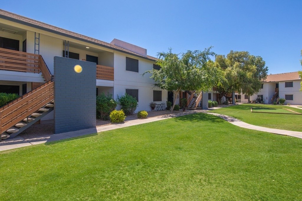 A modern building with a grey sign in front of it.