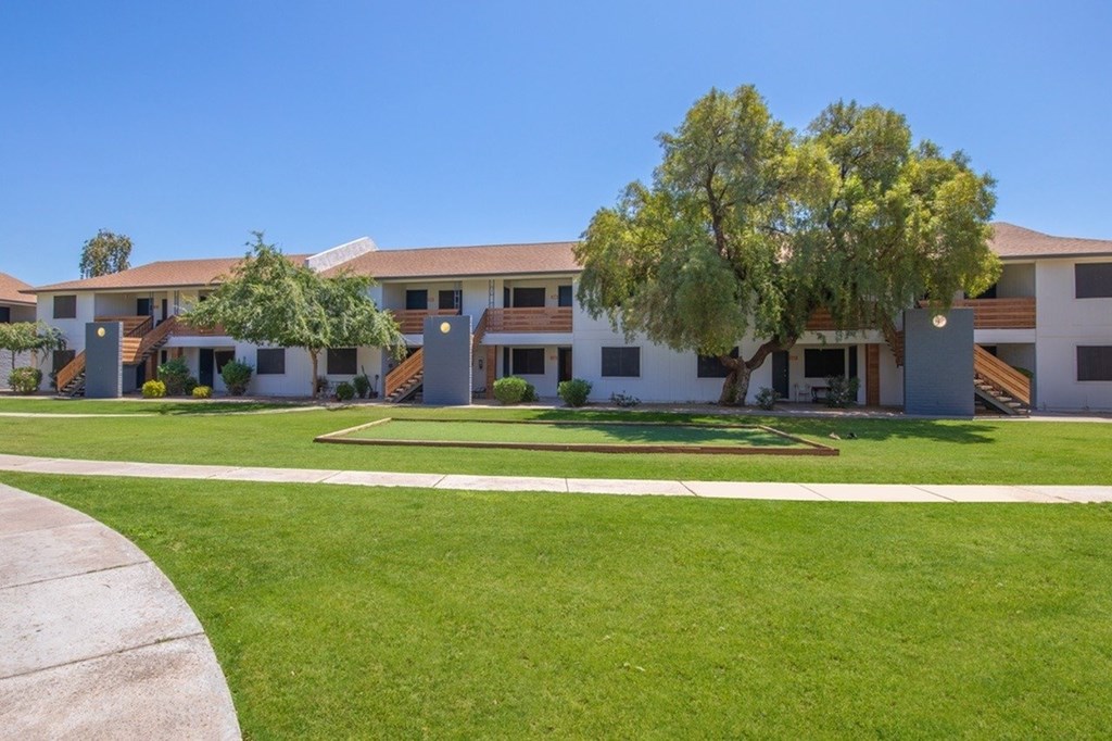 A row of houses with a tree in front of the first one.
