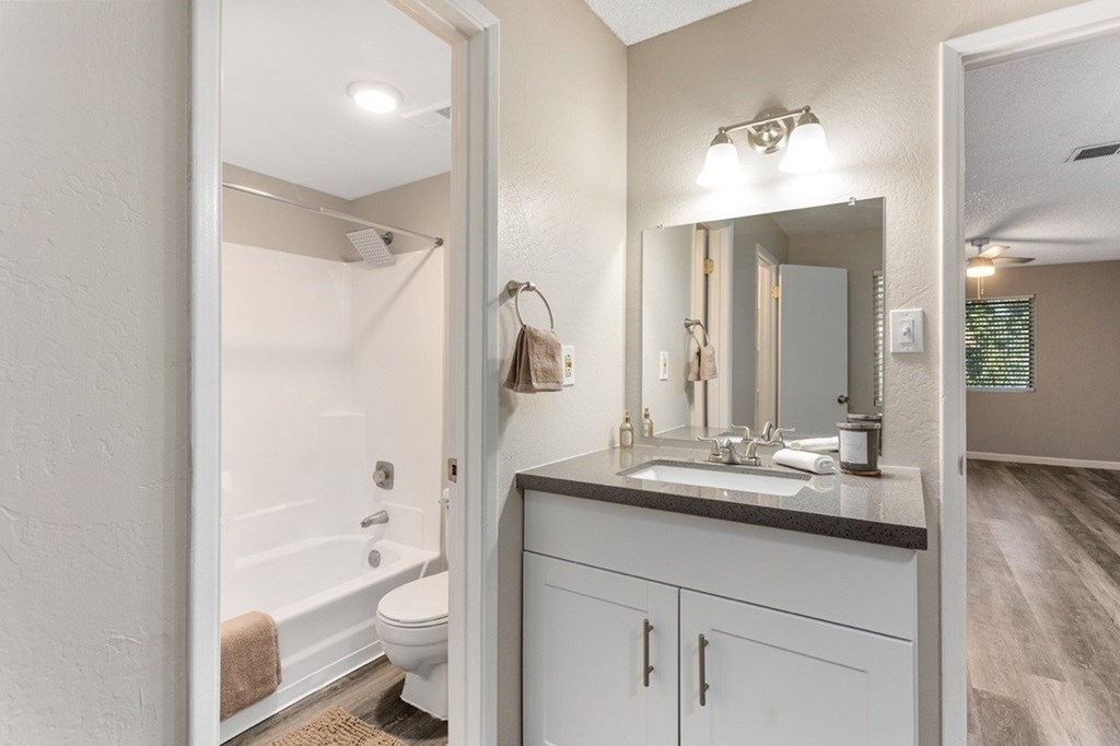 A bathroom with a white tub and sink.