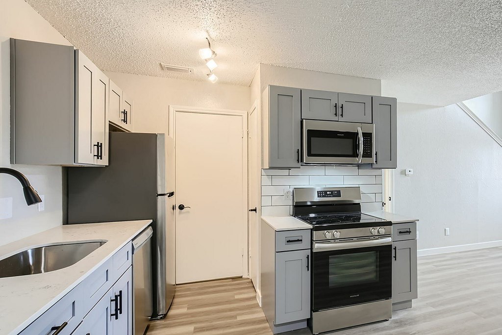 A kitchen with a stove, oven, and microwave.
