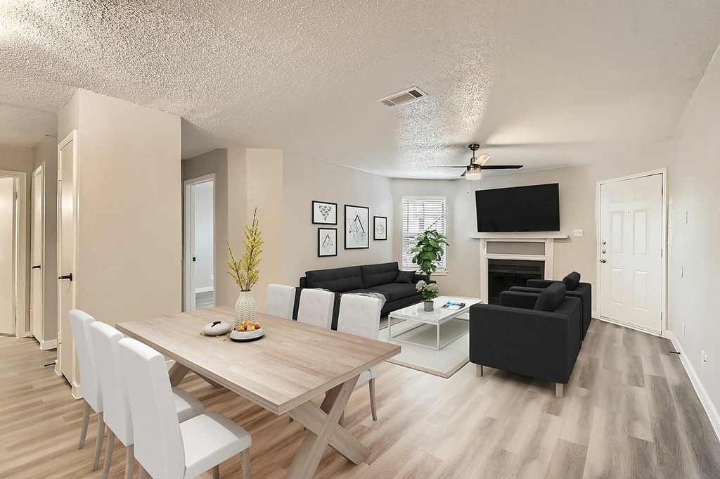 A modern living room with a dining table and chairs.