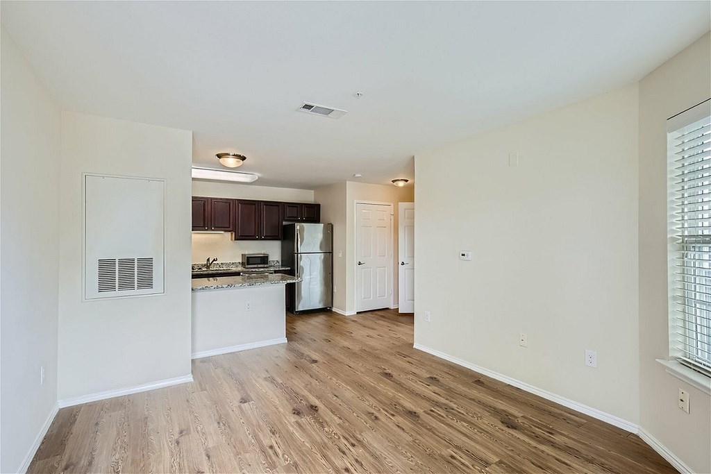 A kitchen with white walls and wooden floors.
