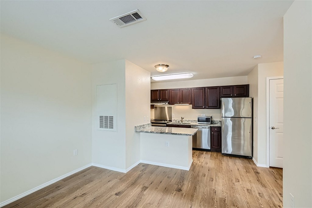 A kitchen with wooden floors and white walls.