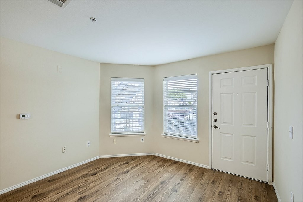 A room with a white door and a window with blinds.