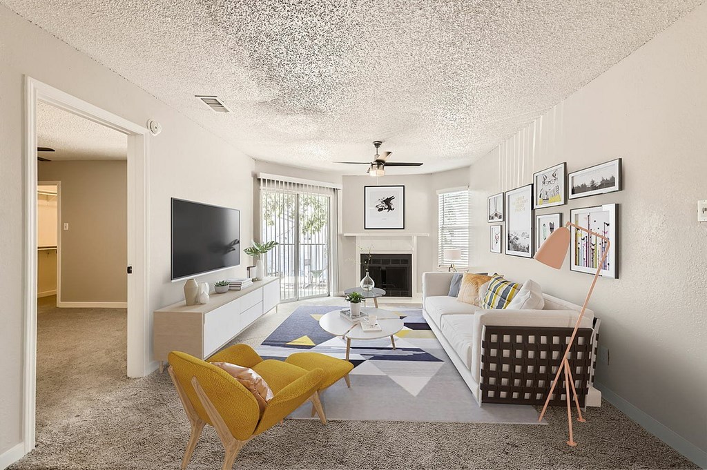 A living room with a yellow chair and a white couch.