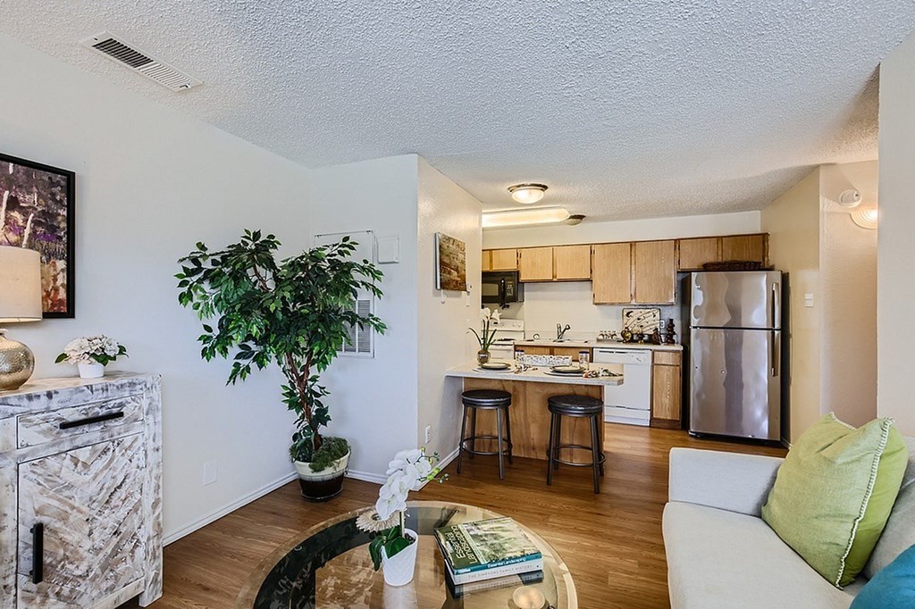 A living room with a couch, a table, and a potted plant.
