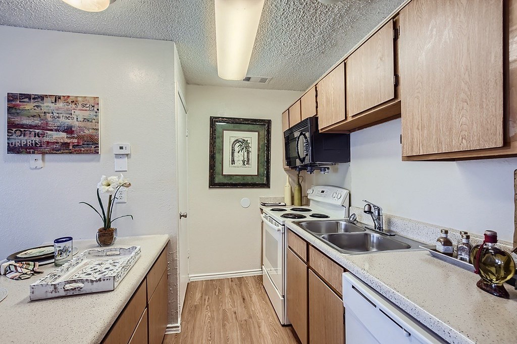 A kitchen with a white stove top oven and a white refrigerator.