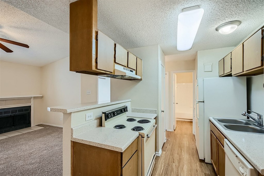 A kitchen with a white counter top and wooden cabinets.