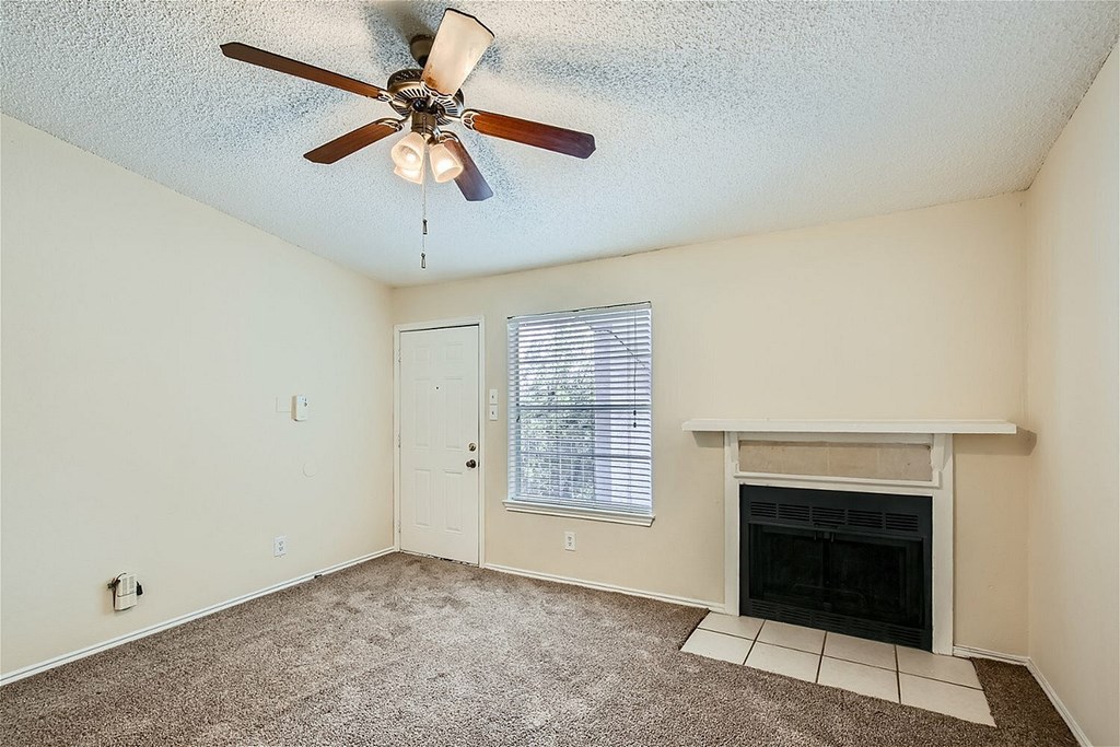 A room with a fireplace and a ceiling fan.