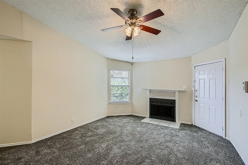 A room with a fireplace and a ceiling fan.