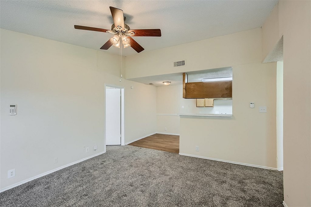 A room with a ceiling fan and a light hanging from the ceiling.