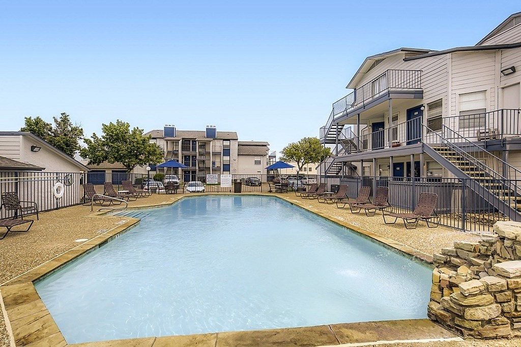 A large swimming pool in front of apartment buildings.