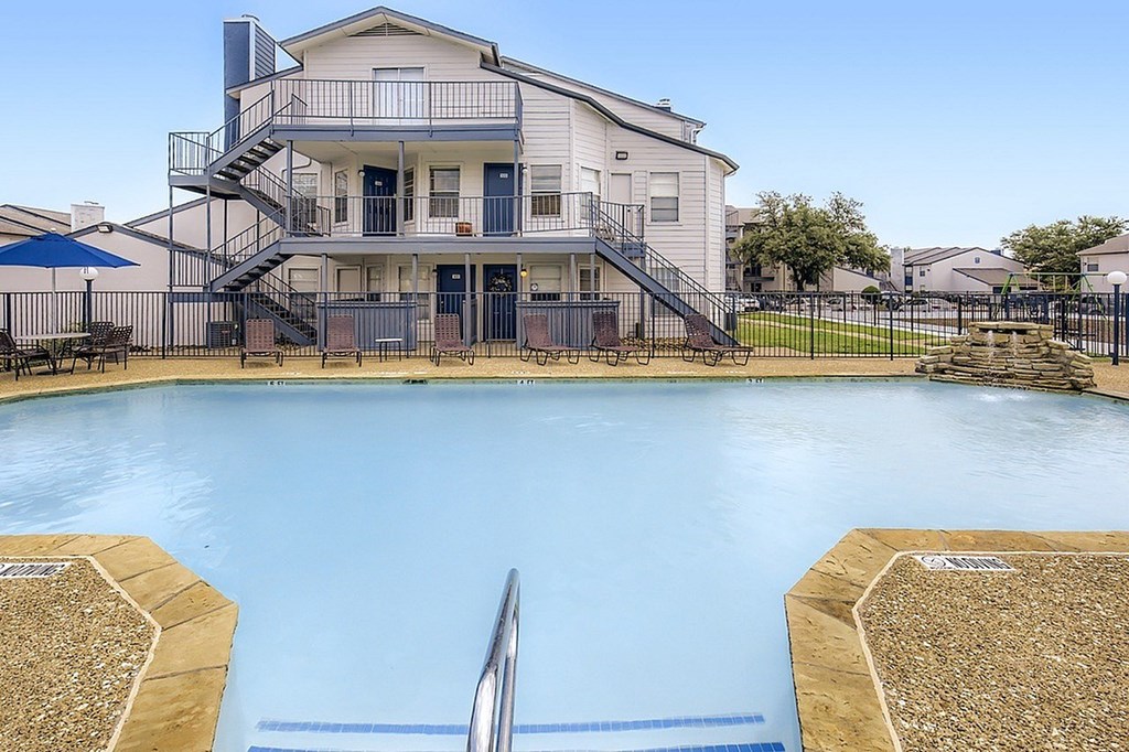 A large house with a pool in front.