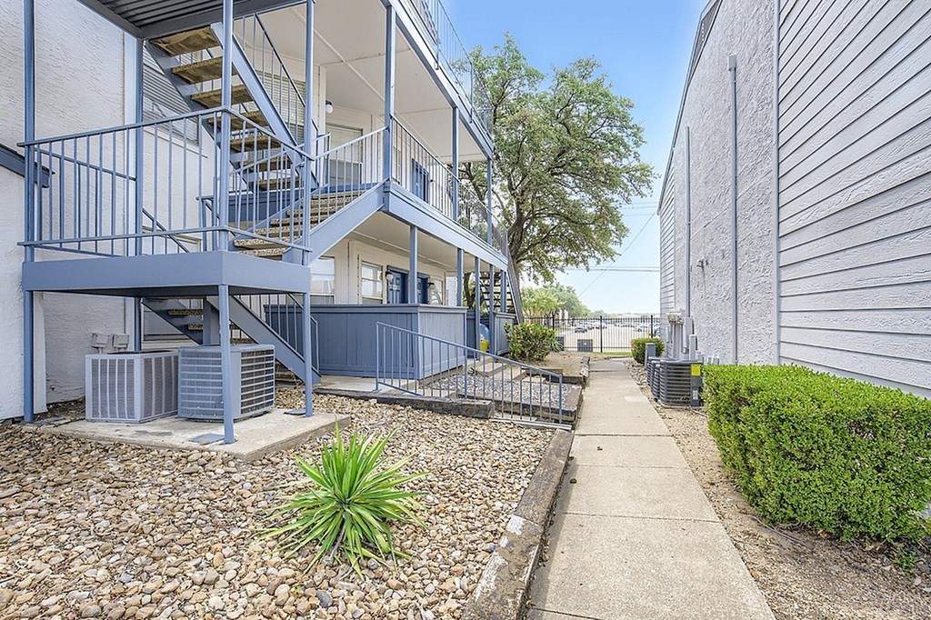 A building with a blue staircase and a concrete walkway.